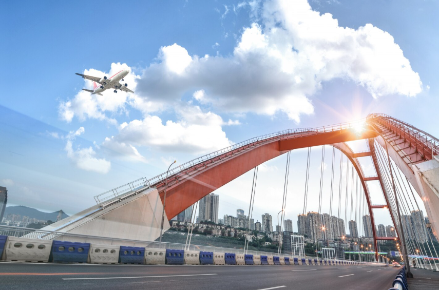 Airplane above a red-arched airport terminal