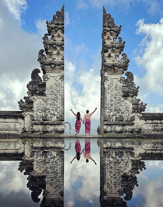 Couple reflected in water at the Gates of Heaven in Bali