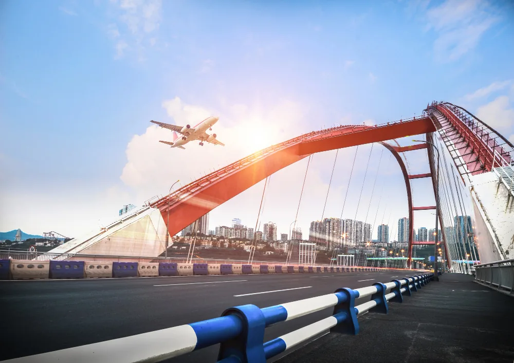 Airplane departing above a red-arched airport terminal